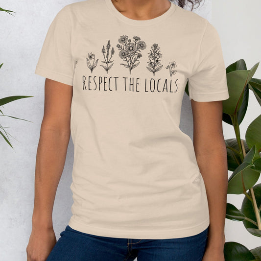 Beige t-shirt with wildflowers and 'respect the locals' text.