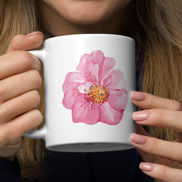 Woman holding a white mug with a floral design.